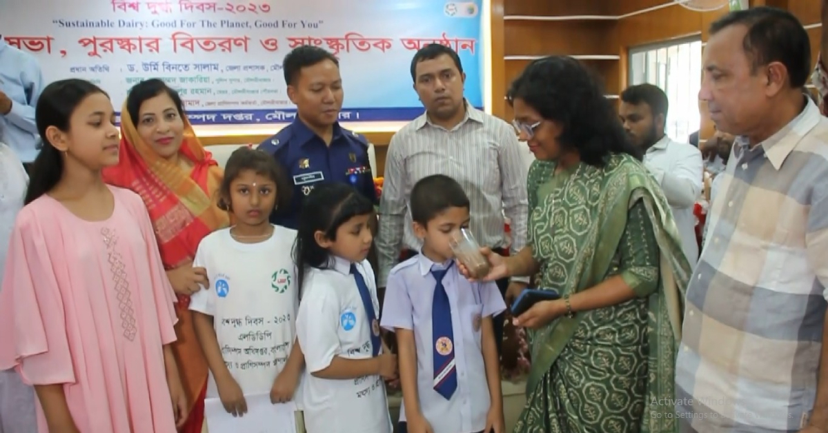 শিশুদেরকে দুগ্ধ পান করাচ্ছেন জেলা প্রশাসক। ছবি- আই নিউজ